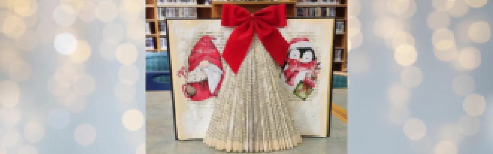 DIY Christmas book art with a red bow and winter illustrations in a library setting.